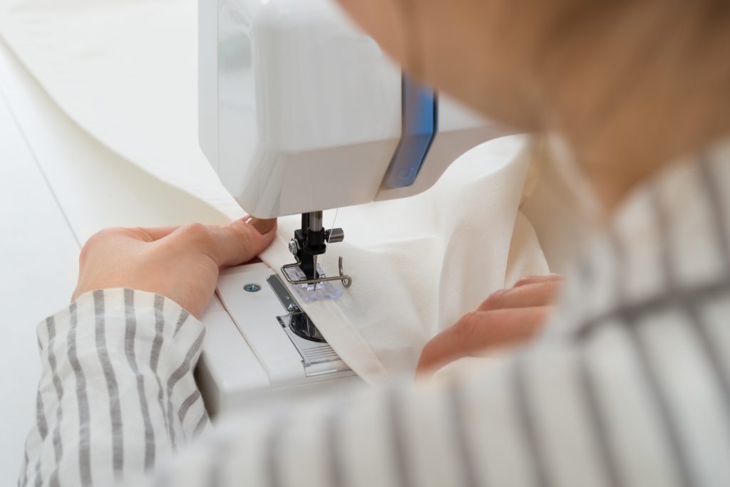 Woman Stitching Fabric on a sewing machine