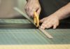 man using a rotary cutter on a piece of leather